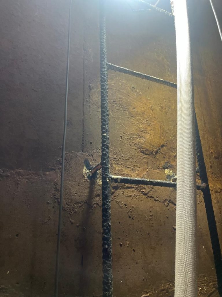 Corroded metal ladder in concrete tank